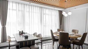A modern meeting room with a long table, chairs, and a ceiling with wooden slats.
