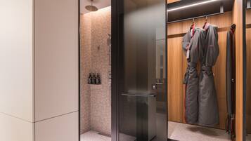 A modern bathroom with a glass shower enclosure, a wooden vanity with a towel rack, and a mirror.