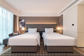 A hotel room with two beds, a sofa, a large window with curtains, and a wall-mounted artwork. - IntercityHotel Zhuhai Nanping Huafa (Zhuhai)