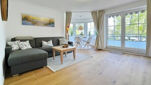 Ein Wohnzimmer mit einer Couch, einem Couchtisch und einem Gemälde an der Wand.