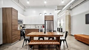Une cuisine moderne avec une table à manger en bois, des chaises noires et un banc.