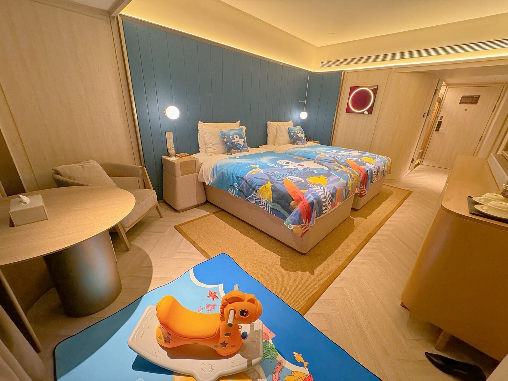 A hotel room with a bed, bedside tables, a desk, and a chair.