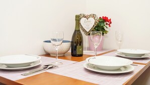 A table set with plates, glasses, a bottle, and a heart-shaped sign. - Vacation apartment with fantastic sea views in Dramalj (Dramalj)