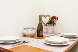 A table set with plates, glasses, a bottle, and a heart-shaped sign. - Vacation apartment with fantastic sea views in Dramalj (Dramalj)