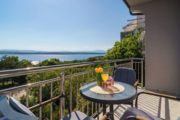 A balcony with a table, chairs, and a view of the sea. - Vacation apartment with fantastic sea views in Dramalj (Dramalj)