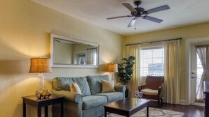 A living room with a sofa, coffee table, and a ceiling fan. - Spacious 2BR Condo at Harbourside Resort, Walk to Beach (Indian Rocks Beach)