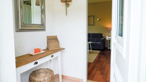 A hallway with a mirror, a wall-mounted lamp, a wicker basket, and a small table with a decorative item. - Vacation Rental "LOTTTALEBEN 1" for up to 4 people (non-smoking) (Timmendorfer Strand)
