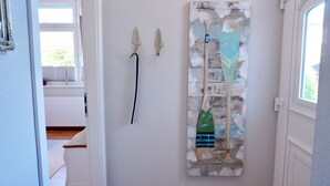 A hallway with a painting of a boat, a door, and a window. - Vacation Rental "LOTTALEBEN 2" for up to 2 people (non-smoking) (Timmendorfer Strand)