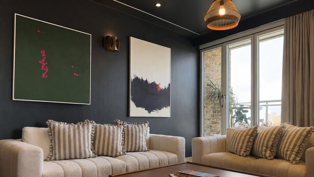 Ein modernes Wohnzimmer mit zwei Sofas, einem Couchtisch und Kunstwerken an den Wänden.