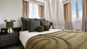 A hotel room with a bed, two bedside tables, a lamp, and a view of the sky. - The Apex Penthouse, Hyde Park (London)