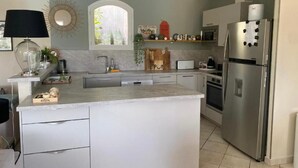 A modern kitchen with a central island, stainless steel appliances, and a window with a view. - Unique Villa Claire de Lune - Jacuzzi - Swimming pool (Sainte-Maxime)
