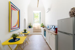 Una cocina estrecha con comedor, una escalera y un ventanal grande.