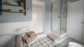 A bathroom with a shower, a towel rack, and a shelf with plants. - Alms House West, Grade II Listed, Garden & Patio (Forthampton)