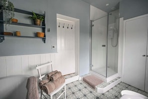 A bathroom with a shower, a towel rack, and a shelf with plants. - Alms House West, Grade II Listed, Garden & Patio (Forthampton)