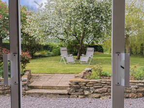 A garden with two lawn chairs, a stone wall, and a grassy lawn. - Harbins Farm (Sherborne)