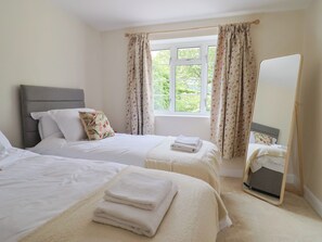 Une chambre d’hôtel avec deux lits, un grand miroir et une fenêtre avec des rideaux.