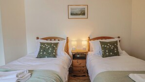 A double room with two beds, each with a pillow and a nightstand with a lamp. - Harbins Farm (Sherborne)