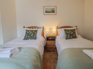 A double room with two beds, each with a pillow and a nightstand with a lamp. - Harbins Farm (Sherborne)