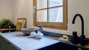 A kitchen with a window, a sink, and various kitchen items.