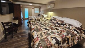 A hotel room with a large bed, a desk, and a chair. There is a door leading to a balcony.