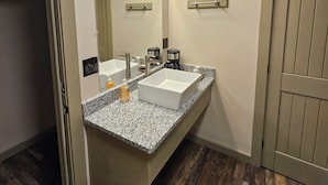 A bathroom with two sinks, a mirror, and a door.