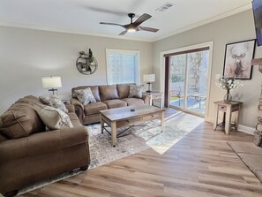 A living room with a brown leather sofa, a wooden coffee table, and a ceiling fan. - UPDATED Downtown Gatlinburg on the strip, Heated Pool, Hot tub (Gatlinburg)