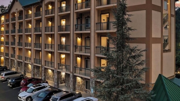 Un hôtel à plusieurs étages, doté de balcons et d’un parking.
