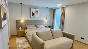 A modern bedroom with a bed, bedside tables, a sofa, a rug, and a painting on the wall. - 4-br Villa, Sleeps 16 With Hot Tub, Pool & Parking (Vrsar)