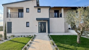 A modern two-story building with a flat roof, a central entrance, and a small balcony on the upper floor. - 4-br Villa, Sleeps 16 With Hot Tub, Pool & Parking (Vrsar)