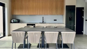 A modern kitchen with wooden cabinets, a built-in oven, and a dining area with six chairs. - 4-br Villa, Sleeps 16 With Hot Tub, Pool & Parking (Vrsar)