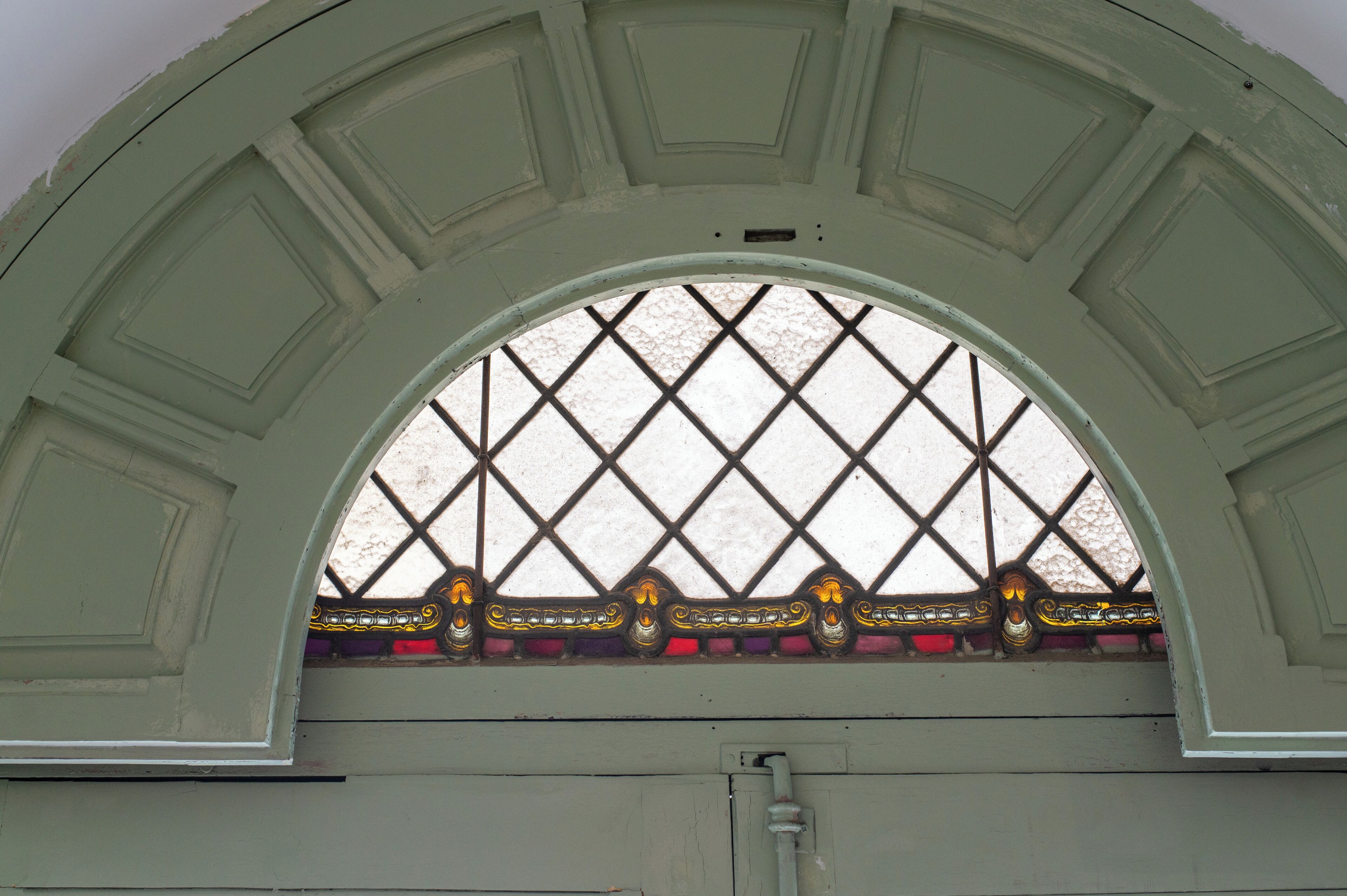 Una ventana con un diseño de diamante y detalles decorativos.