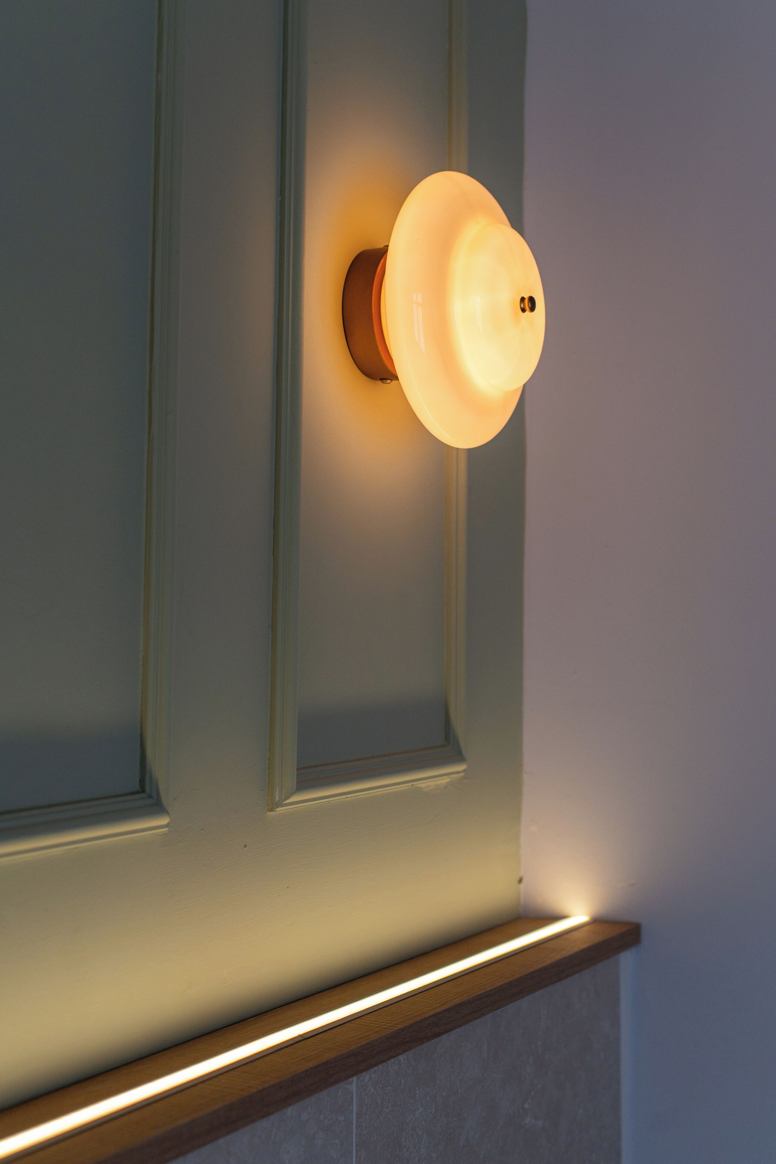 A wall-mounted light fixture with a round, illuminated design.