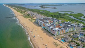 Et kysthotel med flere bygninger, en strand og en mole.