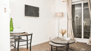 A dining area with a table, chairs, a television mounted on the wall, a lamp, and a view through a glass door. - Entire rental unit in Medway, United Kingdom - A comfort Zone (Gillingham)