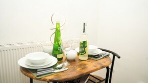 A dining table with plates, cutlery, a green bottle, a white bottle, and a glass. - Entire rental unit in Medway, United Kingdom - A comfort Zone (Gillingham)