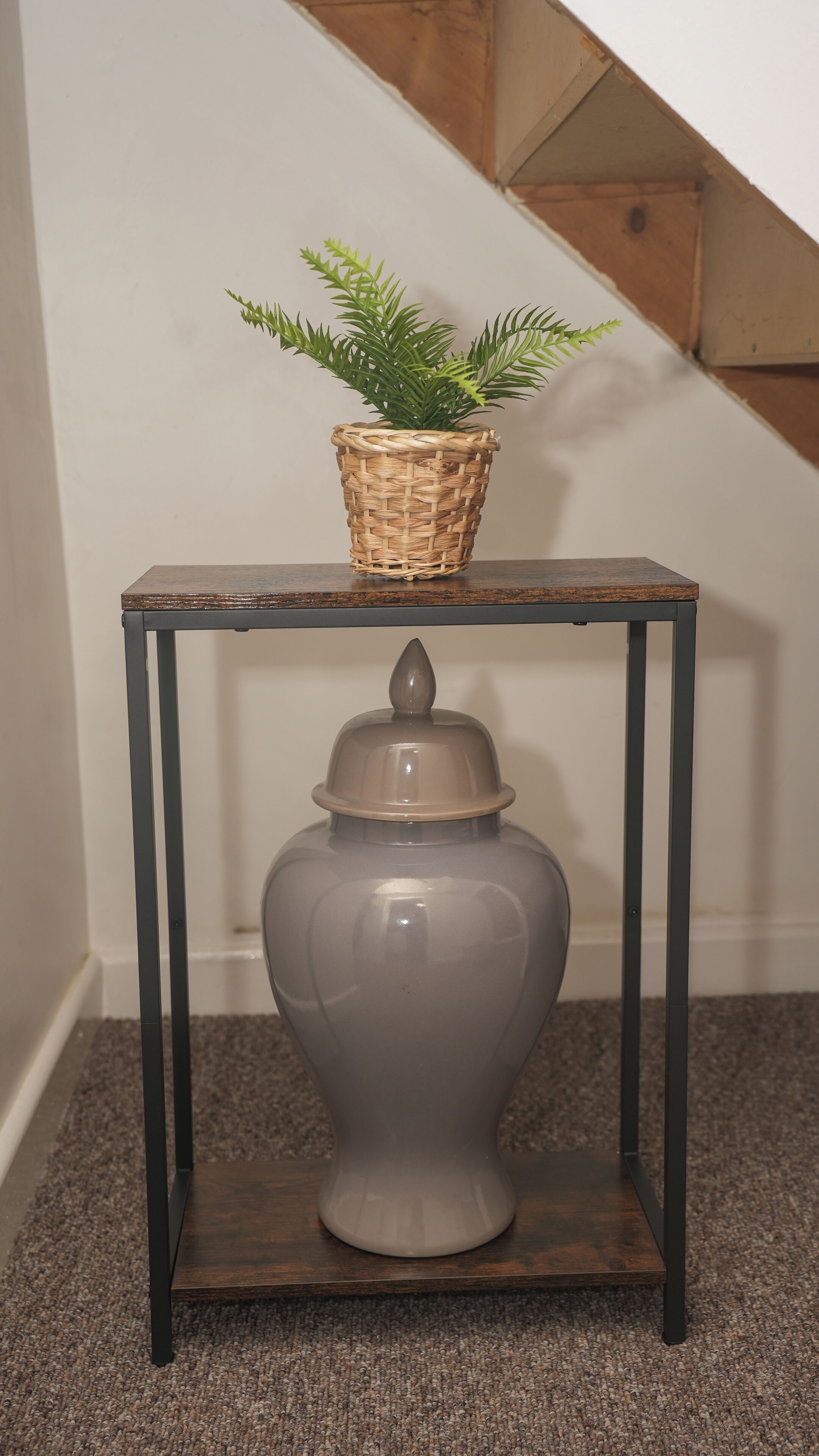 A small table with a woven basket and a ceramic container.