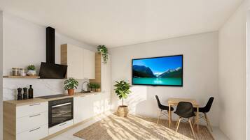 Eine moderne Küche mit Einbauofen, ein Essbereich mit Tisch und Stühlen sowie ein Fernseher, der einen Bergsee zeigt.