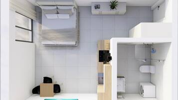 Ein modernes, kleines Hotelzimmer mit Bett, einer kleinen Küchenzeile, einem Badezimmer mit Toilette und Waschbecken sowie einem großen Fenster.
