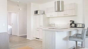 A modern kitchen with a built-in microwave, a coffee maker, and a toaster. - Vacation apartment Hafenperle (Laboe)