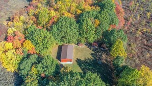 An aerial view of a property with a central building surrounded by dense forest.
