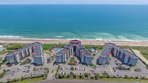 Un hotel moderno con numerosi piani, un cortile interno e vista sulla spiaggia.