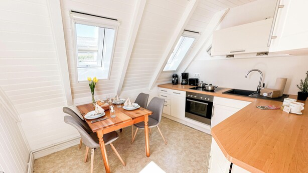 A compact kitchen with a dining area, a small oven, and a sink.