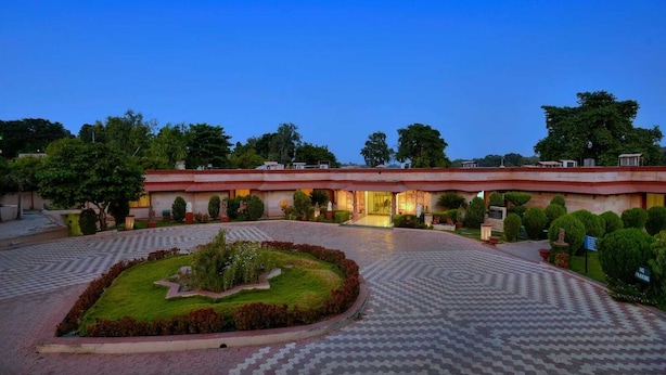 A hotel with a central courtyard, a fountain, and a well-maintained garden. - Orchha Resort- by the river (Nivari)