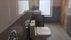 A bathroom with a toilet, sink, and shower.
