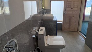A bathroom with a toilet, sink, and shower.