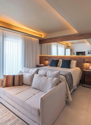 A modern hotel room with a large bed, a sofa, and a TV. - Peace and quiet, stylish design, and parking—just 5 minutes from downtown | LYVVO (Campinas)