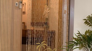A room with a wooden slat partition, a hanging macrame curtain, a potted plant, a woven basket, and a metal bowl with food items. - Comfy 2-bedroom apartment with AC in Santa Maria (Santa Maria)