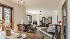 Ein geräumiger Wohnbereich mit Esstisch, Sofa und Fernseher.