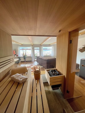 Una sala de estar moderna con muebles de madera, una chimenea y ventanas amplias que dan a vistas del exterior.