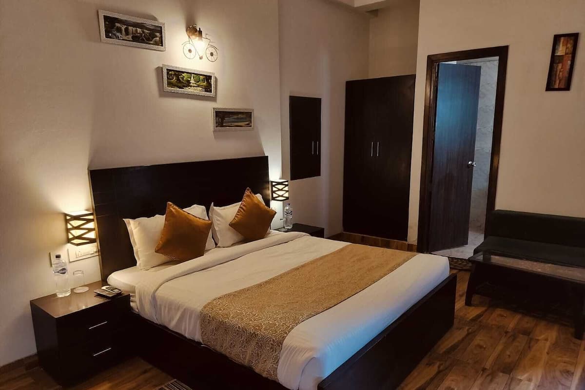 A neatly arranged bedroom with a bed, bedside tables, a wardrobe, and a bench.